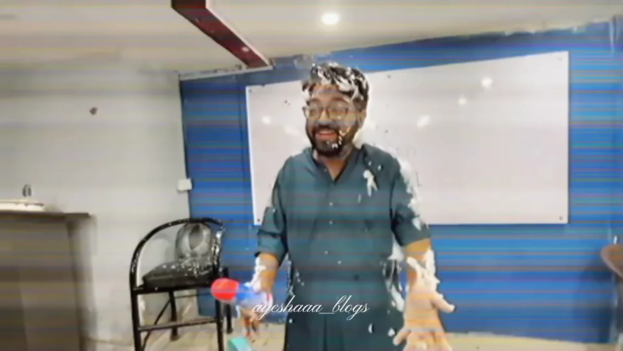 A teacher smiling during a classroom cake celebration